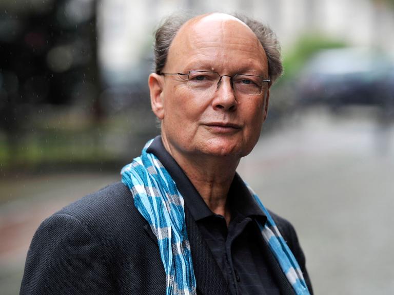 Ein älterer Mann mit Brille blickt in die Kamera.