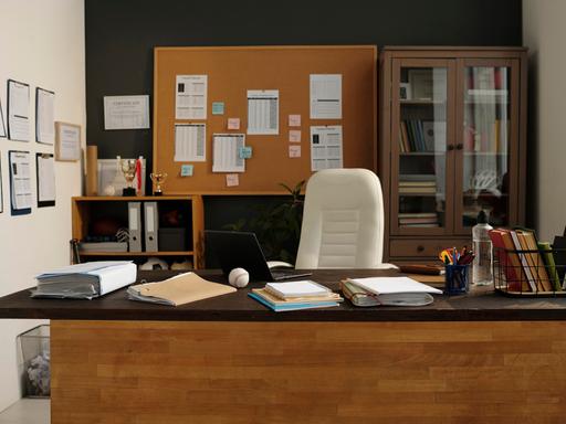 Ein Büro mit großem hölzernen Schreibtisch und Schränken voller Aktenordner und Pokale.