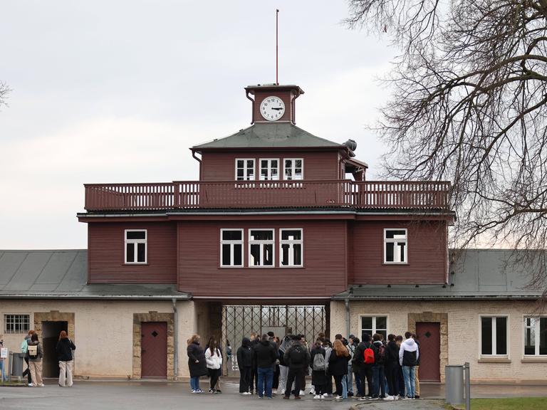 Menschen stehen vor dem Eingang zur Gedenkstätte für das frühere Konzentrationslager Buchenwald bei Weimar