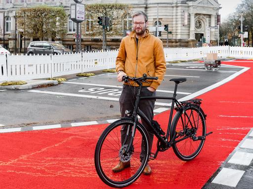 Anjes Tjarks (Bündnis 90/Grüne), Verkehrssenator Hamburgs, steht mit seinem Rad auf einer neu eingerichteten Fahrradspur auf der Esplande.