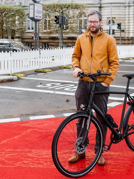 Anjes Tjarks (Bündnis 90/Grüne), Verkehrssenator Hamburgs, steht mit seinem Rad auf einer neu eingerichteten Fahrradspur auf der Esplande.