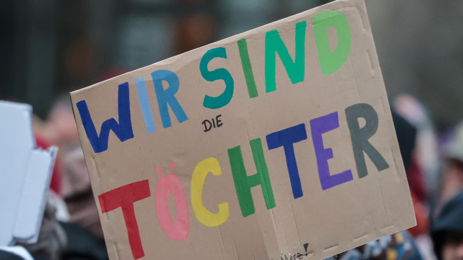 Ein gebasteltes Papp-Schild mit der Aufschrift "Wir sind die Töchter"  Ein gebasteltes Papp-Schild mit der Aufschrift "Wir sind die Töchter"