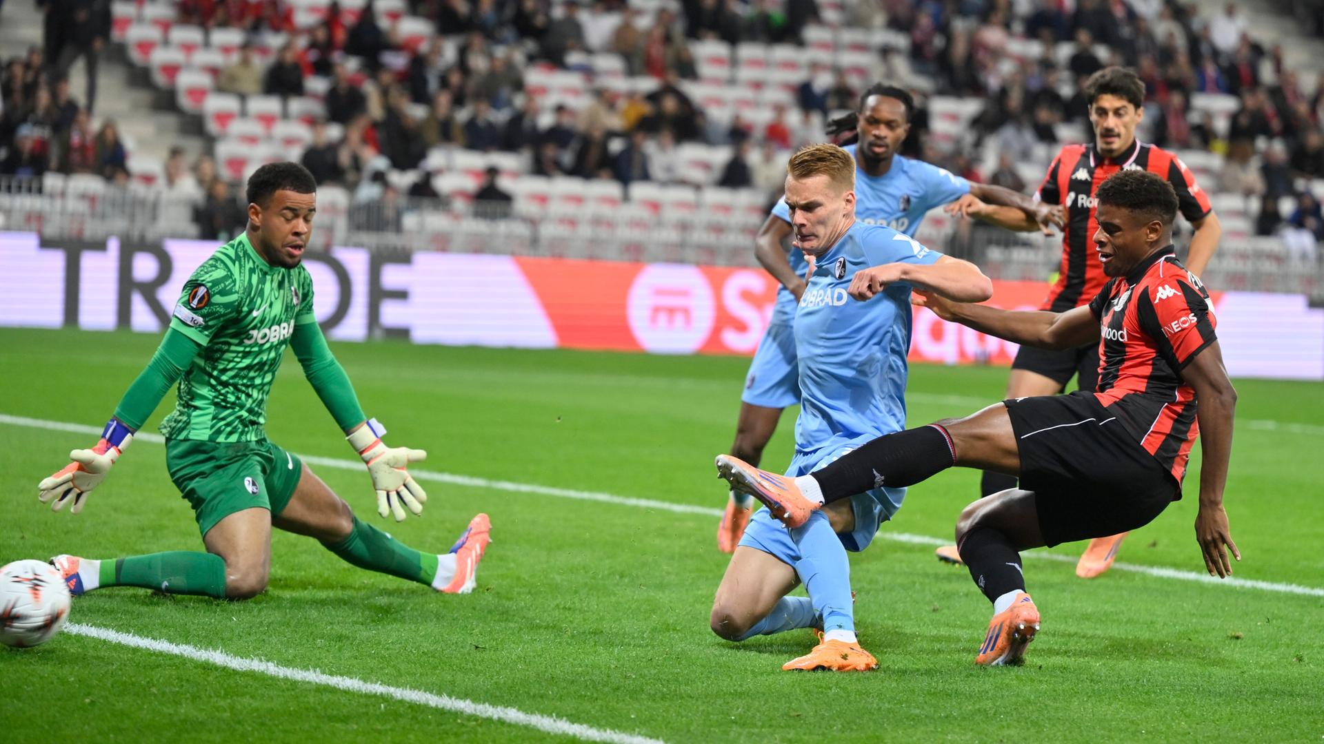 Nizzas Kevin Carlos schießt den Ball am Freiburger Torwart Noah Aubolu vorbei ins Tor. Bei ihm noch zwei Freiburger und ein Teamkollege.