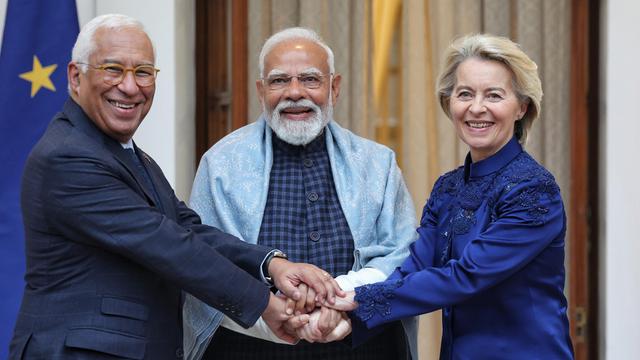 EU-Rats-Präsident Antonio Costa (l.), Indiens Premier-Minister Narendra Modi (Mitte) und EU-Kommissions-Präsidentin Ursula von der Leyen (r.) stehen nebeneinander. Sie haben die Hände übereinander gelegt und lächeln.