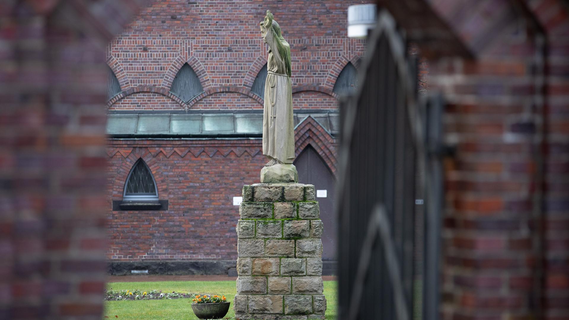 Blick durchs offene Tor auf eine Statue auf dem Gelände vom Thuiner Franziskanerinnen-Orden.