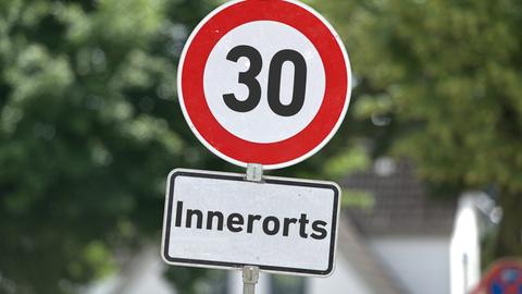 Verkehrszeichen mit der Aufschrift "30" sowie ein Zusatzschild mit der Aufschrift: "Innerorts" an einem Schildermast.