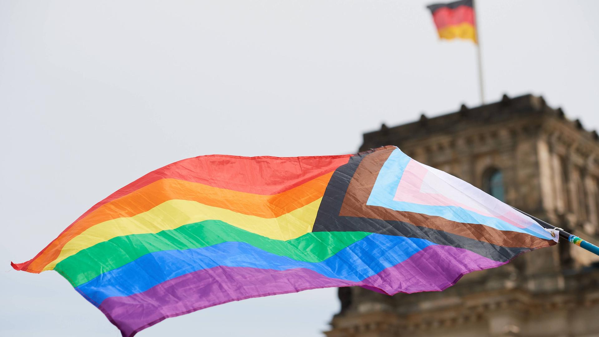 Eine LGBTQ-Regenbogenfahne vor dem Reichstagsgebäude in Berlin.
