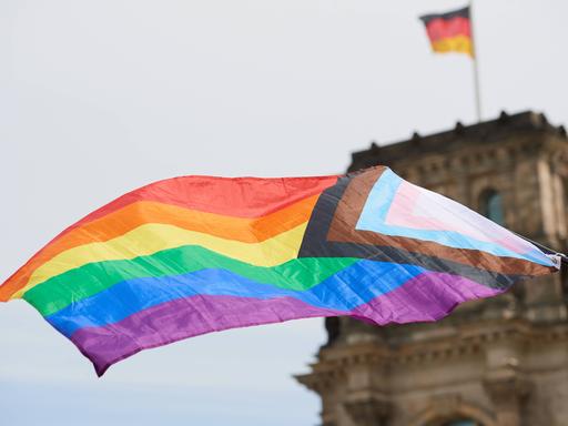 Eine LGBTQ-Regenbogenfahne vor dem Reichstagsgebäude in Berlin.