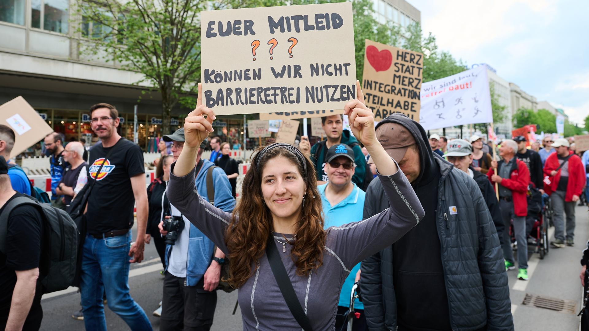 Demonstranten mit Transparenten und Schildern, darunter eines mit der Aufschrift "Euer Mitleid können wir nicht barrierefrei nutzen"