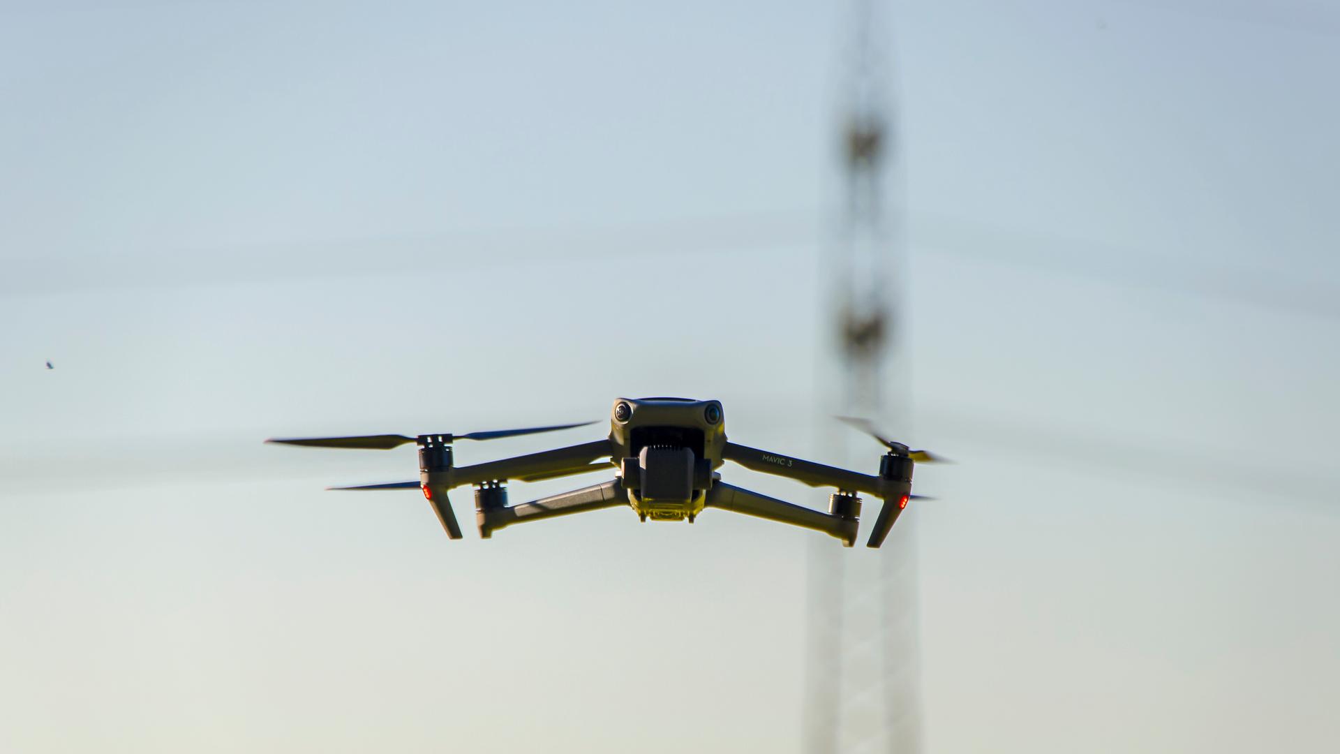 14.05.2025, Bad Woerishofen im Unterallgaeu. Drohne fliegt am Himmel, hinten ein Hochspannungsmast. 14.05.2025, Bad Woerishofen im Unterallgaeu. Drohne fliegt am Himmel, hinten ein Hochspannungsmast.