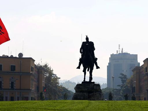 Eine Reiterstatue des albanischen Nationalhelden "Skanderbeg" steht im Stadtzentrum von Tirana neben einer albanischen Flagge.