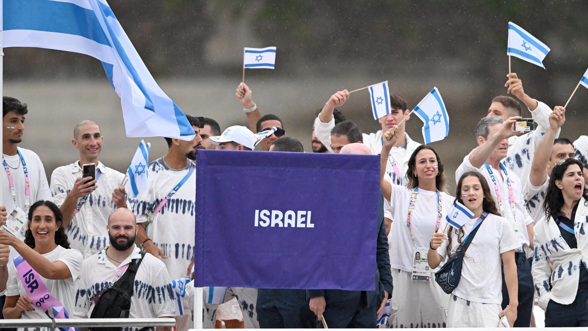 Athleten vom Team Israel schwenken Fahnen.