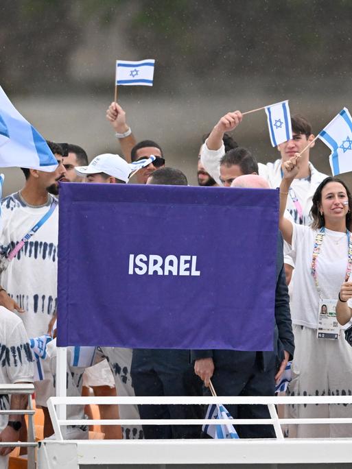 Athleten vom Team Israel schwenken Fahnen.