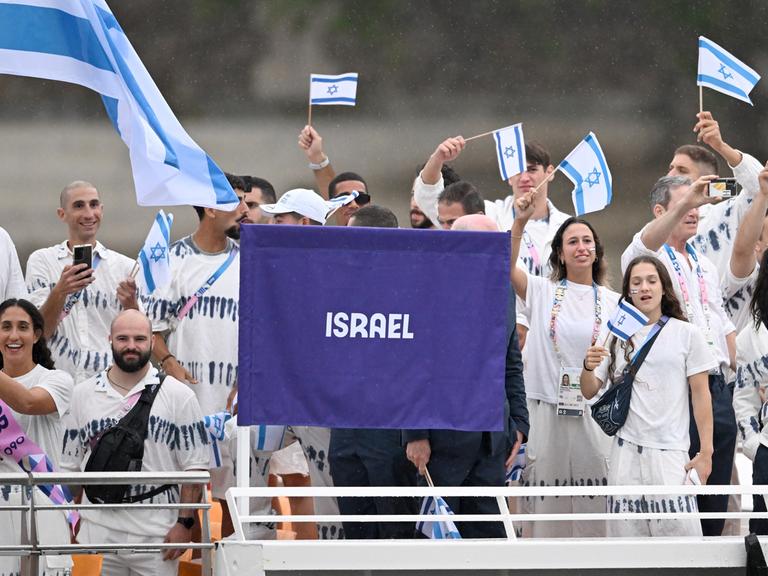 Athleten vom Team Israel schwenken Fahnen.