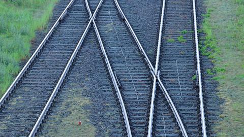 Bahngleise mit Weiche auf schwarzen Schotter, dazwischen wächst teilweise Gras