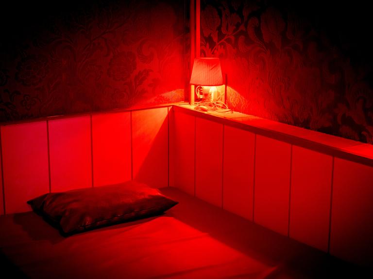 Blick in ein rot beleuchtetes Zimmer im Rotlichtviertel in Amsterdam.