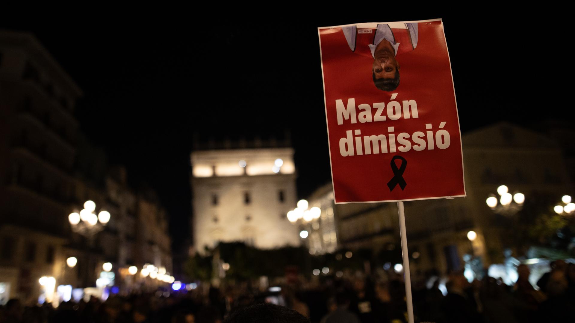 Demonstranten in Valencia halten am 30. November 2024 ein Schild in die Höhe mit der Aufschrift "Mazón dimissió". Demonstranten in Valencia halten am 30. November 2024 ein Schild in die Höhe mit der Aufschrift "Mazón dimissió".