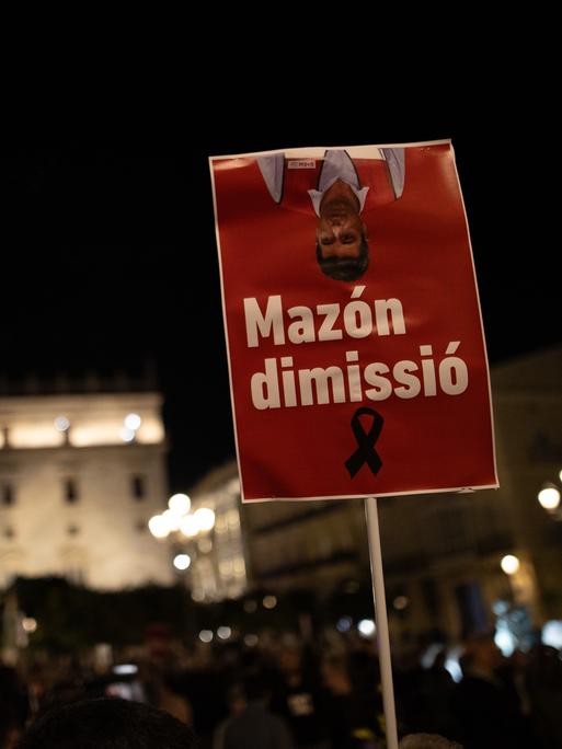 Demonstranten in Valencia halten am 30. November 2024 ein Schild in die Höhe mit der Aufschrift "Mazón dimissió".