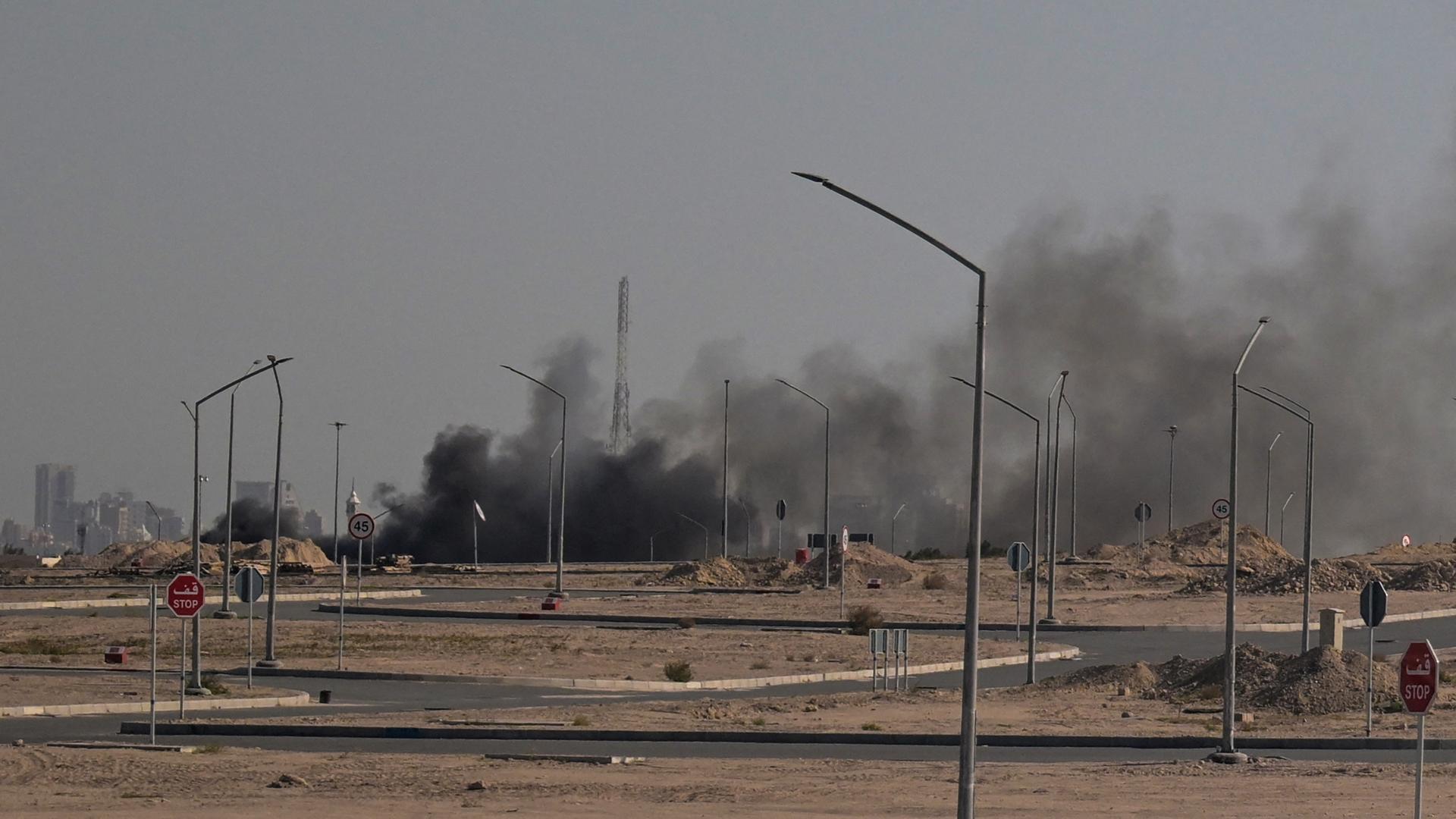 Das Bild zeigt einen Randbezirk von Kuwait-Stadt, über dem schwarzer Rauch aufsteigt. Das Bild zeigt einen Randbezirk von Kuwait-Stadt, über dem schwarzer Rauch aufsteigt.