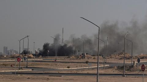 Das Bild zeigt einen Randbezirk von Kuwait-Stadt, über dem schwarzer Rauch aufsteigt. 