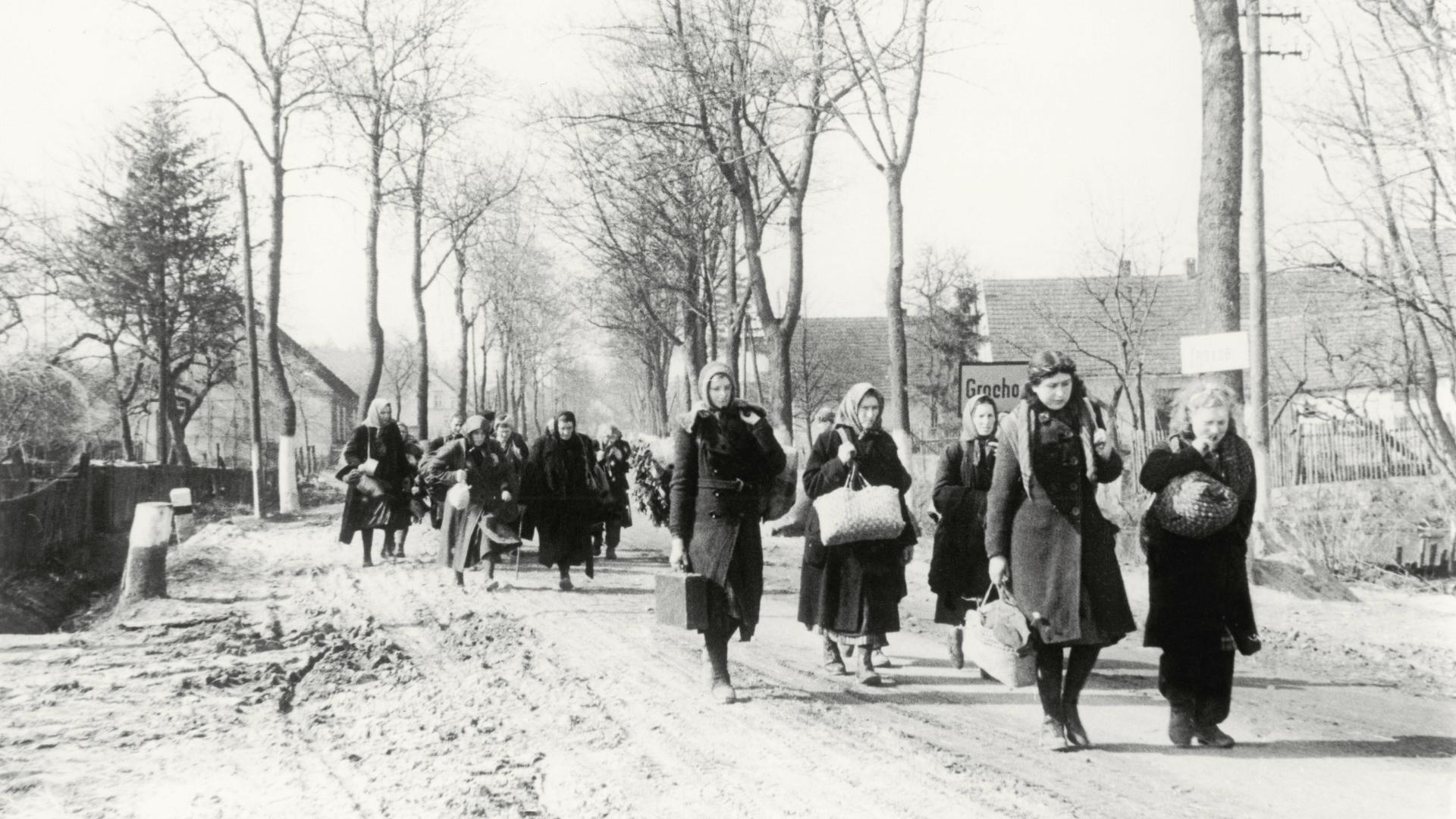 Eine Gruppe Vertriebener zieht 1946 durch das Dorf Grochow.