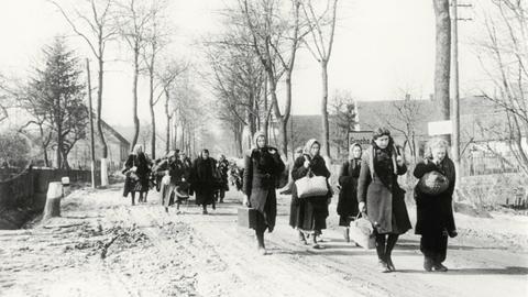 Eine Gruppe Vertriebener zieht 1946 durch das Dorf Grochow.