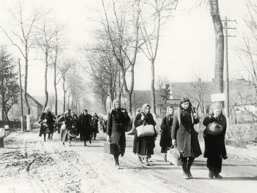 Eine Gruppe Vertriebener zieht 1946 durch das Dorf Grochow.