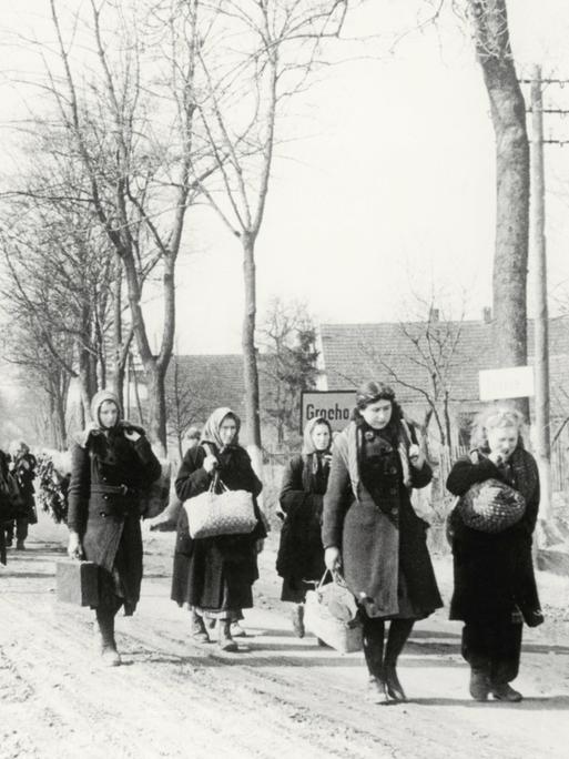 Eine Gruppe Vertriebener zieht 1946 durch das Dorf Grochow.