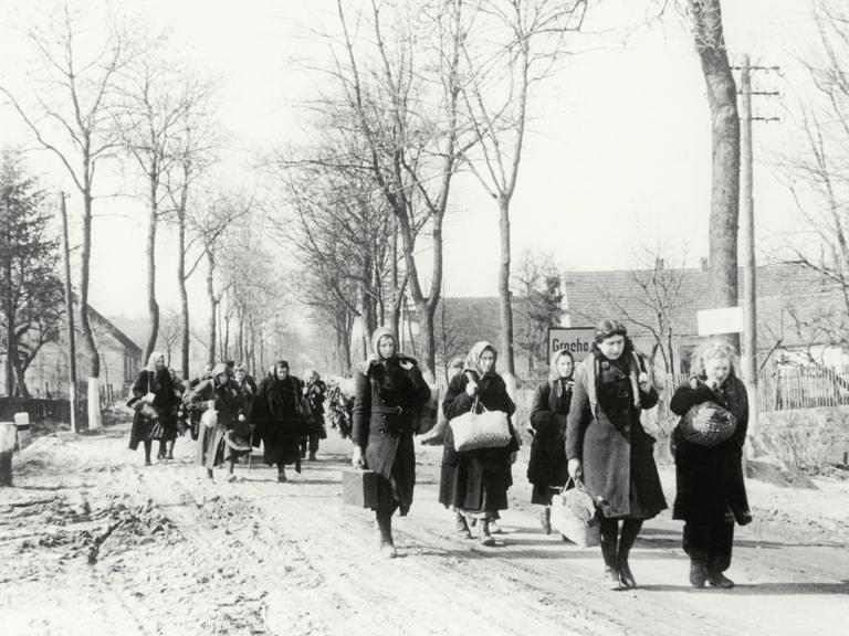 Eine Gruppe Vertriebener zieht 1946 durch das Dorf Grochow.