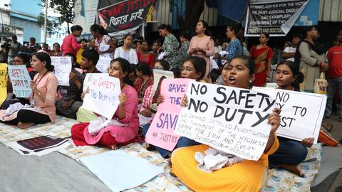 Viele junge Frauen sitzen auf dem Boden und halten Plakate. Auf mehreren von ihnen ist zu lesen "No Safety - No Duty".