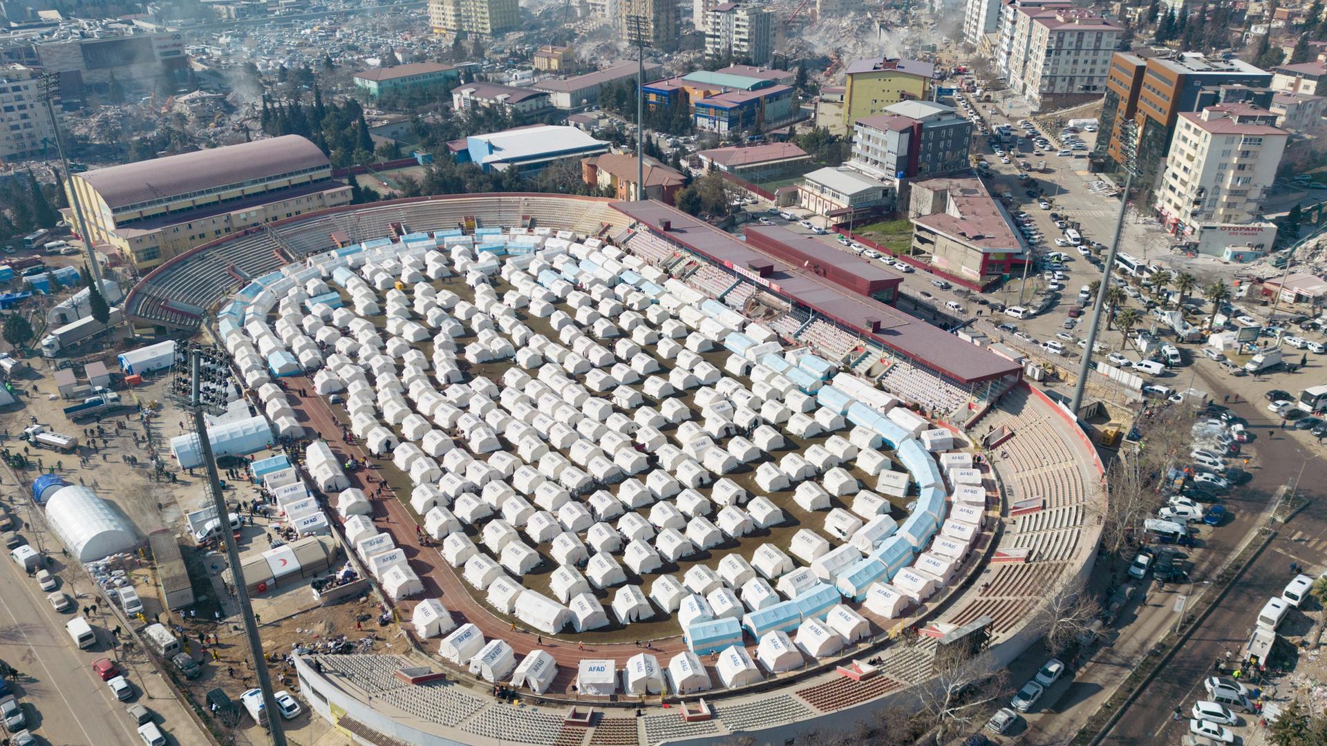 Ein Zeltlager im Innenraum des Fußballstadions in Kahramanmaraş aus der Vogelperspektive.