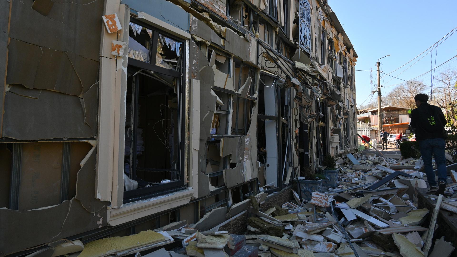 Ukraine, Odessa: Ein Mann geht an Wohnhäusern vorbei, die durch einen russischen Angriff beschädigt wurden. 