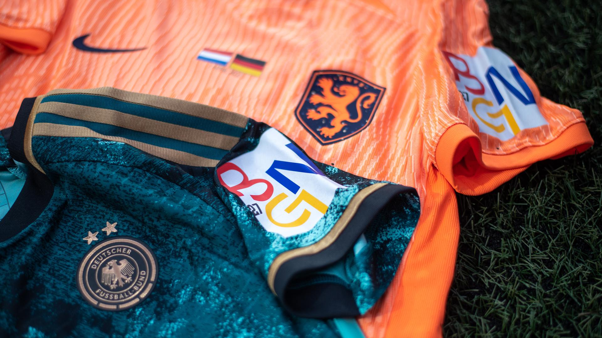 Das grüne Auswärtstrikot der deutschen Frauen-Fußball-Nationalmannschaft und das Trikot der Niederländerinnen mit dem Logo der gemeinsamen Bewerbung der Niederlande, Deutschland und Belgien liegt auf dem Boden