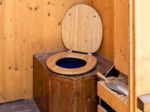 Eine WC-Komposttoilette, auch Trockentoilette genannt,  mit einer Holzumrahmung