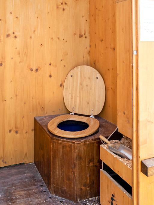 Eine WC-Komposttoilette, auch Trockentoilette genannt,  mit einer Holzumrahmung