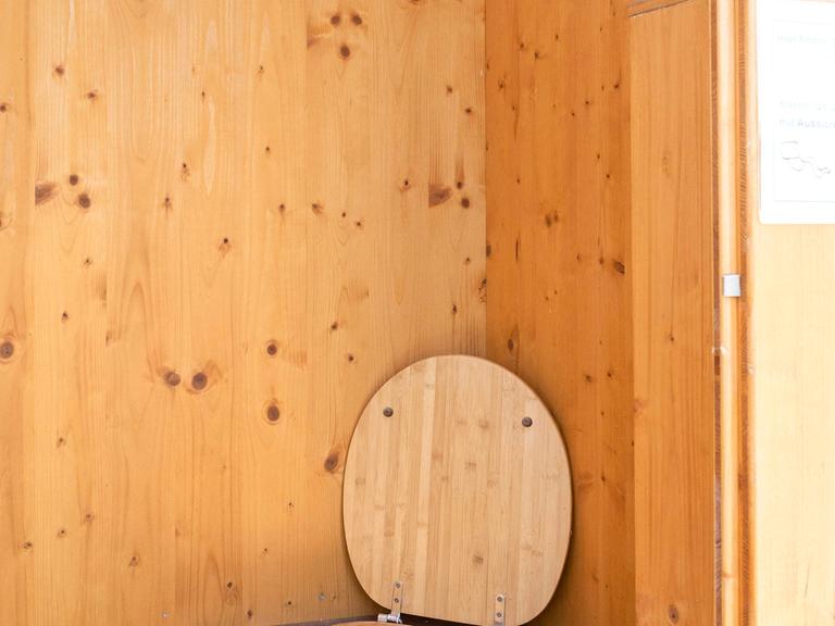 Eine WC-Komposttoilette, auch Trockentoilette genannt,  mit einer Holzumrahmung
