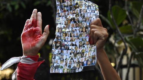 Angehörige der Opfer der Explosion im Hafen von Beirut versammeln sich während einer Protestaktion, bei der eine faire Untersuchung der Explosion im Hafen am 4. August 2020 gefordert wird. Sie tragen Bilder der Getöteten und halten rote Hände in die Luft.