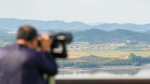 Ein Besucher schaut mit einem Fernglas von Paju in Südkorea aus über die Grenze und die demilitarizierte Zone  nach Nordkorea