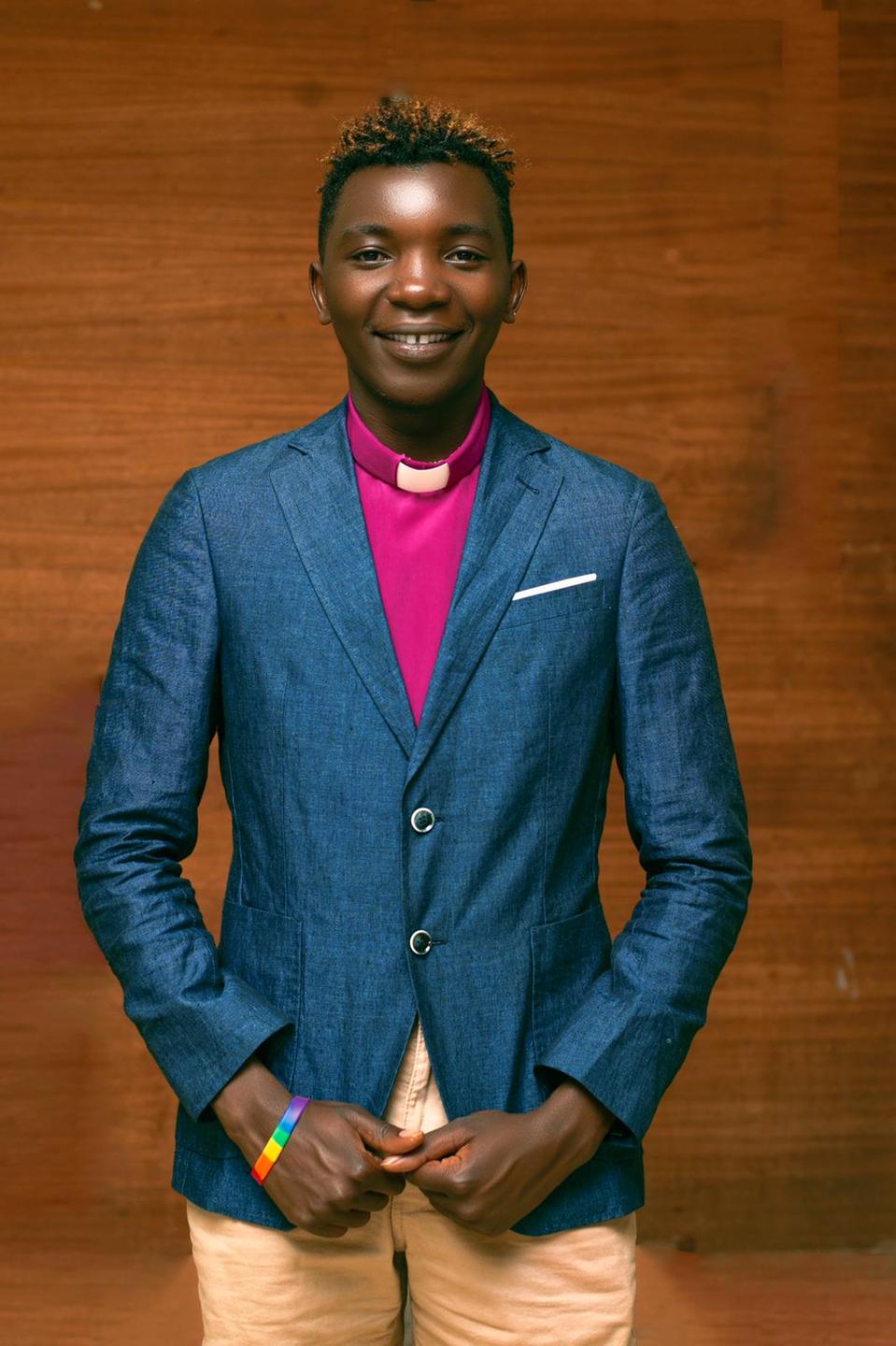 Pastor Ramathan Kaggwa, Mitbegründer der queerfreundlichen Kirche „Adonai Church" in Uganda. Ein junger Mann mit kurzen Haaren lächelt in die Kamera. 