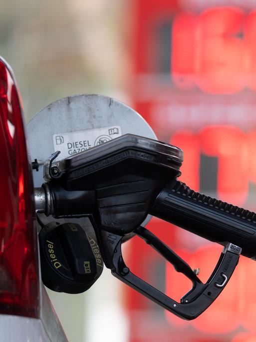 Ein Tankstutzen an einer Tankstelle in der Tanköffnung eines Fahrzeugs.