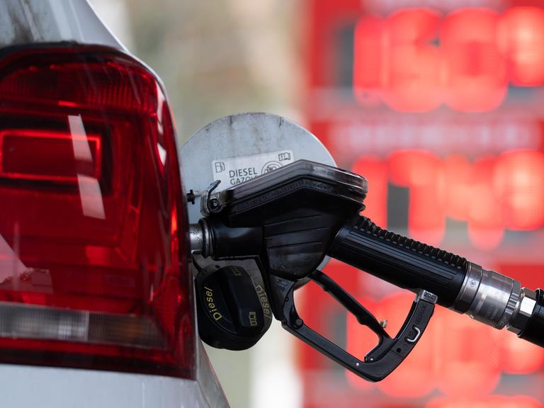 Ein Tankstutzen an einer Tankstelle in der Tanköffnung eines Fahrzeugs.