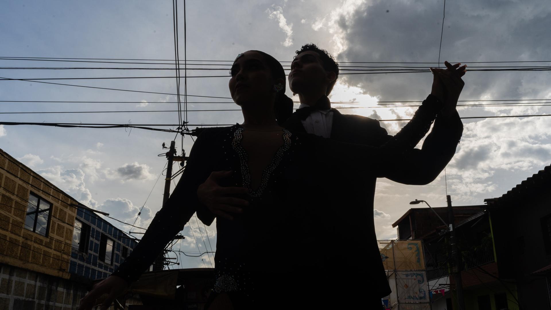 Die Silhouetten von zwei Tango Tanzenden sind unter freiem Himmel zu sehen.