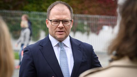 Carsten Schneider im Anzug spricht vor dem Kanzleramt mit Journalisten.