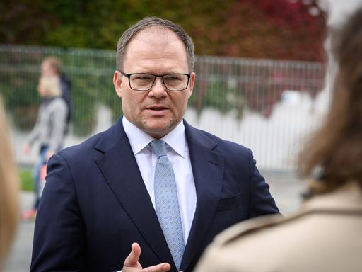 Carsten Schneider im Anzug spricht vor dem Kanzleramt mit Journalisten