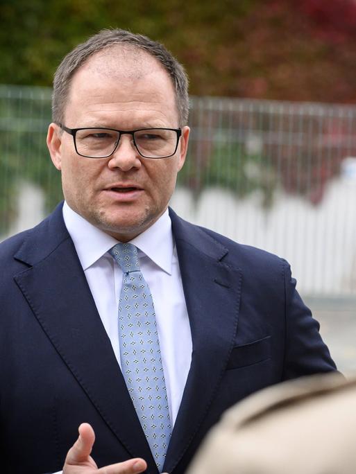 Carsten Schneider im Anzug spricht vor dem Kanzleramt mit Journalisten