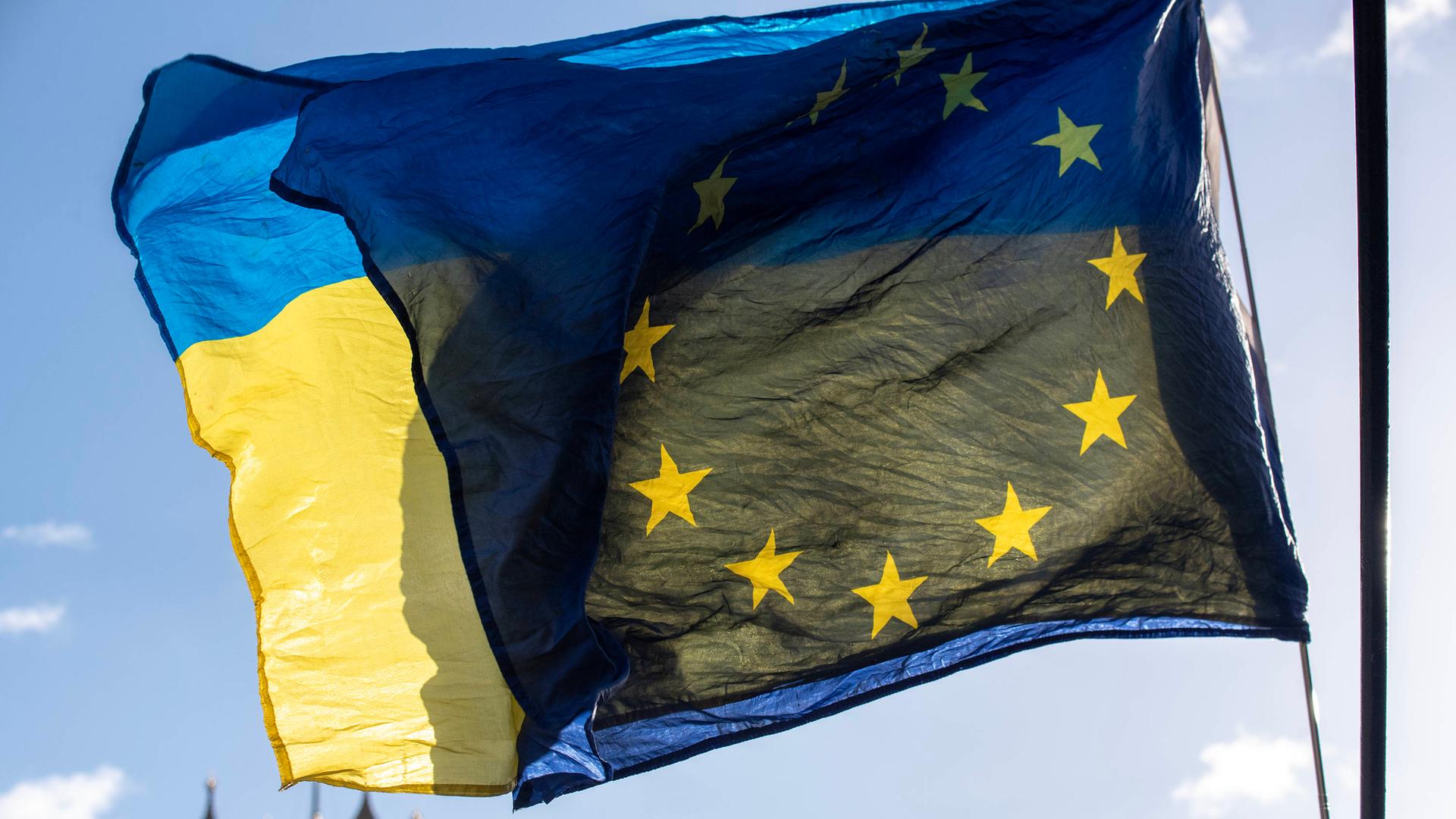 Die Flaggen der Ukraine und der EU wehen voreinander.