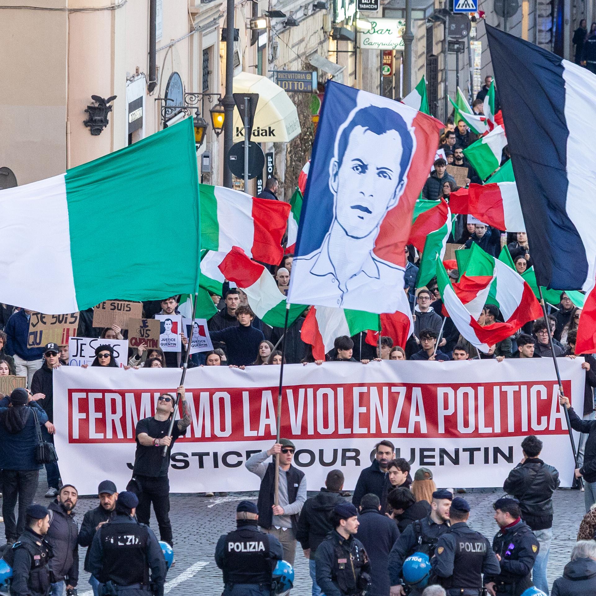 Das Bild zeigt einen Protestzug vieler Menschen in Lyon. Sie tragen Plakate und Banner. Im Vordergrund sind Polizisten zu sehen.