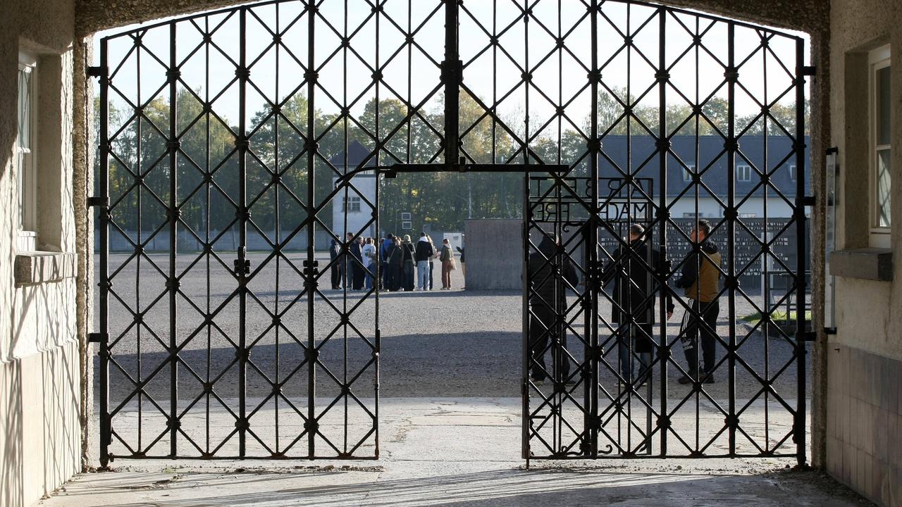 Besucher hinter dem Eingangstor an der KZ-Gedenkstätte Dachau.
