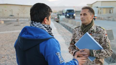 Die afghanische Ortskraft Omid S. (l.) unterhält sich am 11.12.2014 im Camp Marmal in Masar-i-Scharif in Afghanistan mit dem uniformierten Fregattenkapitän Frank Martin.
