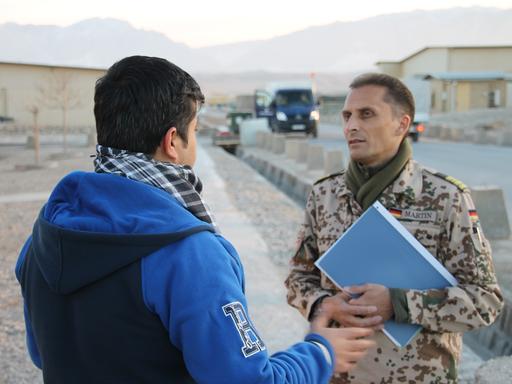 Die afghanische Ortskraft Omid S. (l.) unterhält sich am 11.12.2014 im Camp Marmal in Masar-i-Scharif in Afghanistan mit dem uniformierten Fregattenkapitän Frank Martin.